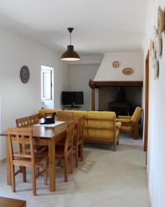 een woonkamer met een tafel en stoelen en een bank bij Casa da Maria Moca in Fátima