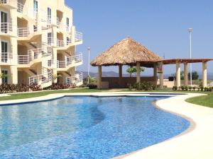 a swimming pool in front of a building at Marina Diamante in Acapulco