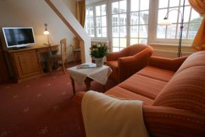 a living room with a couch and a table at Der Fischländer Garni in Ahrenshoop