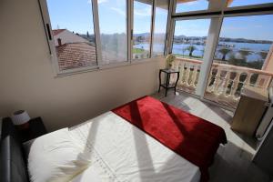 ein Schlafzimmer mit einem Bett und einem großen Fenster in der Unterkunft Sea View Apartments Pericic in Sukošan