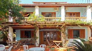 a house with a deck and tables and chairs at Pousada Manaca in Abraão