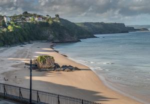 a view of a beach with a fence and the ocean at Royal Lion Hotel in Tenby