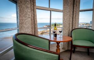 a room with a table and two glasses of wine at Royal Lion Hotel in Tenby