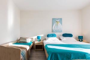 2 Betten in einem blau-weißen Zimmer in der Unterkunft Sea View Apartments Pericic in Sukošan