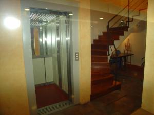 ein gläserner Aufzug in einem Raum mit einer Treppe in der Unterkunft Hostal Adarnius in La Bisbal
