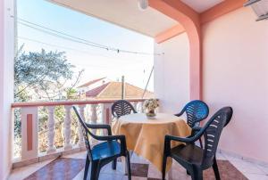 ein Tisch und Stühle auf einem Balkon mit Aussicht in der Unterkunft Sea View Apartments Pericic in Sukošan