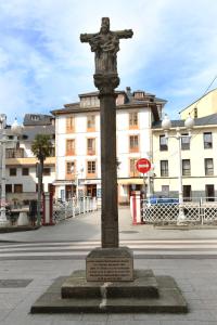 a statue of a man on a pole on a street at Hotel Restaurante Oviedo in Luarca