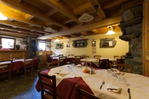 a dining room with tables and chairs in a restaurant at L' Aroula Rooms & Restaurant in Champoluc