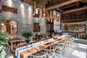 a restaurant with a long wooden table and chairs at Water Hotel, Pingyao in Pingyao