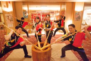 um grupo de pessoas a brincar com tacos de basebol de madeira em Shimobe Hotel em Minobu