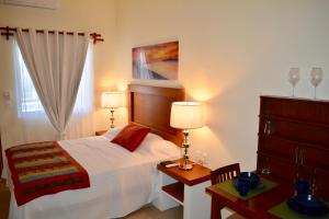 a bedroom with a bed and a dresser with two lamps at Suites SanRey in Puerto Morelos
