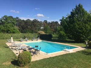 a swimming pool with chaise lounges and chairs around it at Les 2 Brigards in Monestier