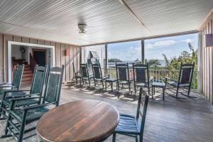 un gruppo di sedie e un tavolo in legno su una terrazza di Roanoke Island Inn a Manteo