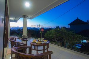 um pátio com uma mesa e cadeiras numa varanda em Nengah House Ubud em Ubud