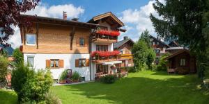 a house with flowers on the balconies in a yard at Landhaus Mayer in Oberstdorf