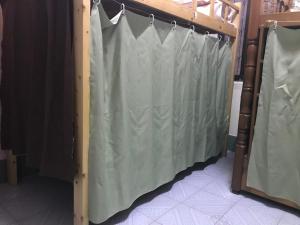 una cortina de ducha colgando en una habitación en Kwangchowan Hostel, en Zhanjiang