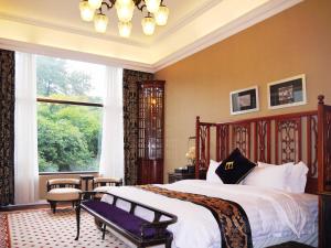 Un dormitorio con una cama grande y una ventana en The White House Museum Hotel Guilin, en Guilin