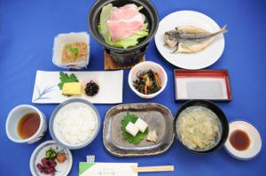einen Tisch mit Teller mit Lebensmitteln und Schüsseln mit Lebensmitteln in der Unterkunft Yusakaso in Hakone