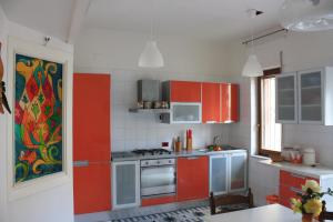 索倫托的住宿－Sorrento Nest Rose，厨房配有红色橱柜和炉灶烤箱