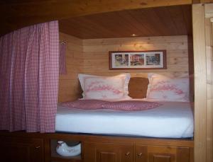 1 cama en una cabaña de madera con ventana en La Roulotte de la Vallée du Lot, en Le Temple-sur-Lot