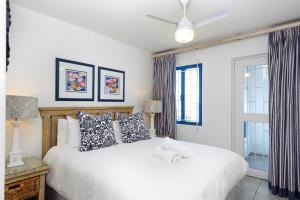 a bedroom with a white bed and a window at Le Paradis 23 in Ballito