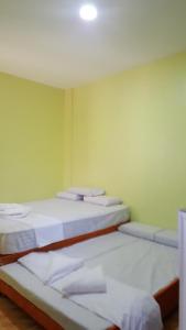 un grupo de 3 camas en una habitación en Honeybee apartments, en Bantayan Island