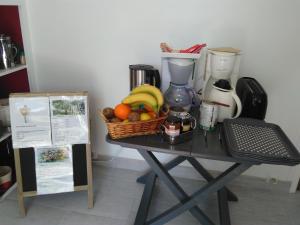 a table with a basket of fruit and a blender at Le champ des étoiles in Massoulès