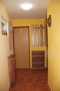 un pasillo con puerta y una habitación con paredes amarillas en Vinný sklep u Konečků, en Mikulčice