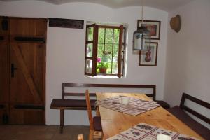 a dining room with a wooden table and a window at Vinný sklep u Konečků in Mikulčice