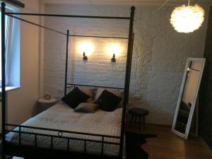 a bedroom with a metal canopy bed with pillows at Apartament Ważka in Gdynia