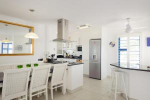 a white kitchen with a counter and a refrigerator at Le Paradis 30 in Ballito