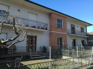 ein Apartmenthaus mit einem Zaun davor in der Unterkunft Casa Santa Gemma in Camaiore