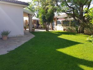 a yard with green grass next to a house at Gentarrubia in Capoterra