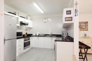 a white kitchen with white appliances and a table at Le Paradis 5 - With Inverter in Ballito