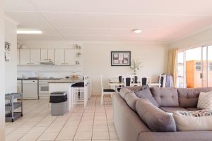 a living room with a couch and a kitchen at Long Island 11 - FAMILY ONLY in Ballito