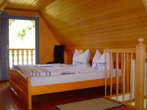 Cama en habitación de madera con ventana en Reethaus im Ostseebad Trassenheide en Trassenheide