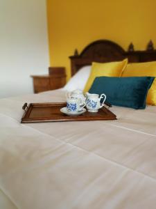 a tray with two tea cups on a bed at Apartment Bandaron in Kobarid