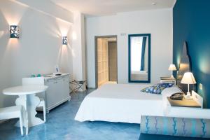 ein Schlafzimmer mit einem Bett, einem Tisch und einem Spiegel in der Unterkunft Hotel Cutimare - Aeolian Charme in Acquacalda