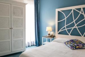 ein Schlafzimmer mit einem Bett und einer blauen Wand in der Unterkunft Hotel Cutimare - Aeolian Charme in Acquacalda