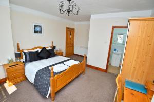 Schlafzimmer mit einem Bett und einem Spiegel in der Unterkunft Home from Home Guesthouse in Leiston