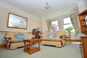 een woonkamer met 2 stoelen en een tafel bij Home from Home Guesthouse in Leiston
