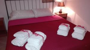 カステッランマーレ・デル・ゴルフォにあるCasa di Loryの赤毛布の上に白いタオルが付いたベッド