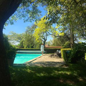 a woman standing next to a swimming pool at Le Clos de Bénédicte in Bondues