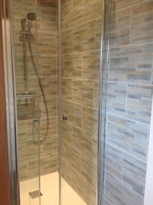 La salle de bains est pourvue d'une douche avec une porte en verre. dans l'établissement Le petit Orchard, à Bonneville-la-Louvet