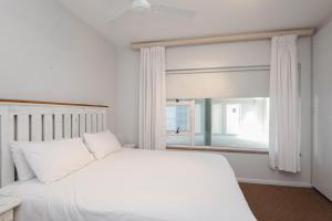 a bedroom with a white bed and a window at Suntrap 6 - FAMILY ONLY in Ballito