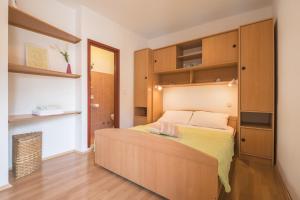 a bedroom with a bed with a wooden headboard at Apartments Maria in Cavtat +44 photos