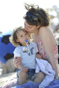 a woman holding a child on the beach at Martinhal Sagres Beach Family Resort Hotel in Sagres