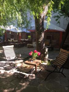 2 Stühle und ein Tisch unter einem Baum mit Blumen in der Unterkunft The Bookies Apartments in Sofia