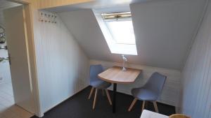 ビューズムにあるWesterstrasse Kajütenのテーブルと青い椅子2脚が備わる小さな客室です。