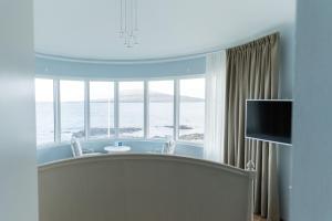 um quarto com vista para o oceano através de uma janela em Havgrim Seaside Hotel 1948 em Tórshavn